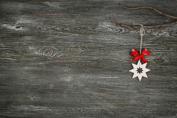 Christmas decoration hanging on branch against wooden background