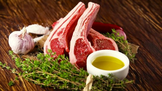 Black Pepper being poured over Raw lamb cutlets steak