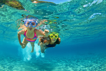 Happy family - mother with baby girl dive underwater with fun in sea pool. Healthy lifestyle, active parent, people water sport outdoor adventure, swimming lessons on beach summer holidays with child