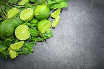 Limes and mint on stone background. Top view with copy space