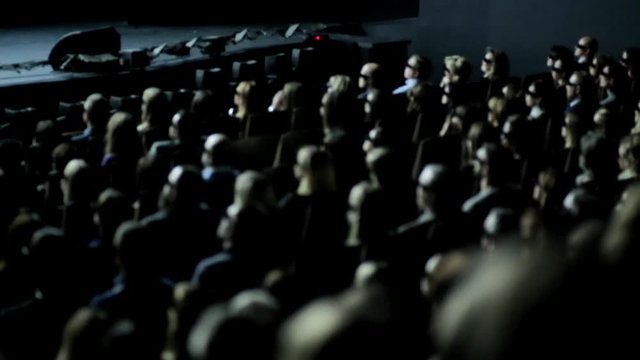 Group of people in 3D glasses watching movie in cinema