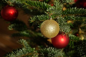 Obraz na płótnie Canvas Boules de Noël or et rouges dans sapin vert