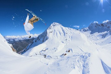 Naklejka na ściany i meble Ski rider jumping on mountains. Extreme freeride sport.