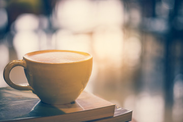 Hot latte coffee and spoon with books