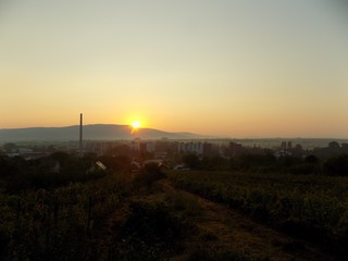 Fototapeta na wymiar Sunrise over hill over city