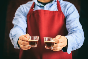 Barista holding two espresso cups