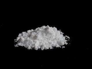Cocaine drug powder pile on black background