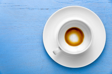 Empty a coffee cup on blue wooden background. Top view with copy space
