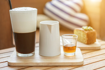 Ice coffee, Milk and Syrup shot on nature wood plate with sunlight background.