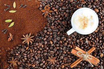 Background with coffee. Overhead view of ground coffee on a roasted whole, unground coffee bean background.