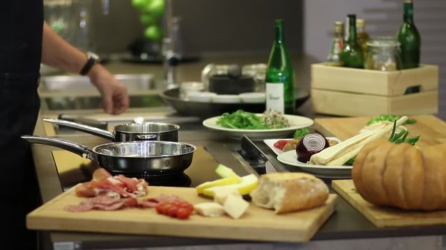 Koch schwenkt Pfanne, schmeckt ab mit Wein