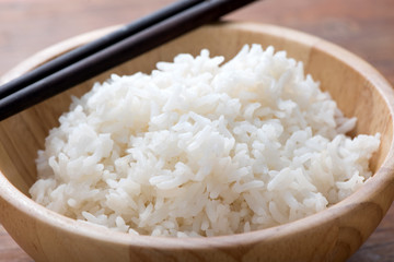 Rice in a bowl on wooden background