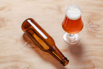 Beer glass and bottle on wood