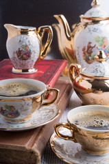 Antique porcelain coffee cups with coffee and crockery