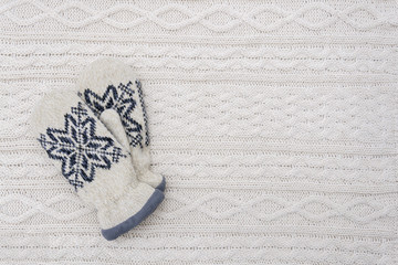 Pair of mittens on white knitted background