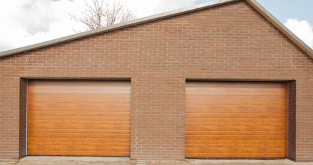 Brick wall and two garage doors.
