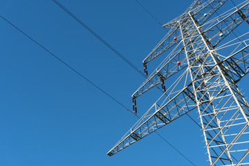 Strommast auf einem Acker mit blauem Himmel