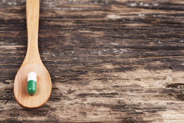 Medical concept,pills,tablets, spoon wood on wooden background