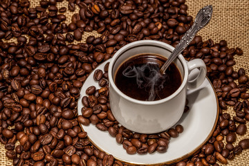 Cup of coffee on coffee beans
