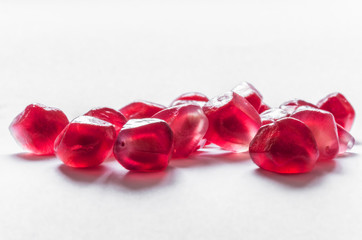 Transparent pomegranate seeds isolated on a white background. Selective focus.