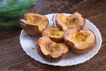baked quince on a plate on a wooden background