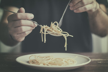 hombre sujetando cubiertos con pasta