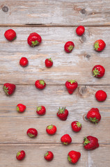 Naklejka na ściany i meble Fresh strawberries scattered on a wooden surface