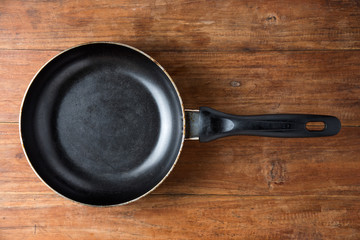 iron skillet on wooden table background.