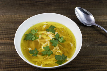 Chicken soup with noodles and parsley leaves. Traditional polish food.