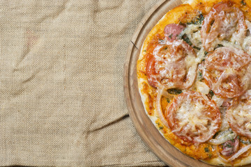 Hot pizza with melting cheese on a rustic wooden table. space for text 