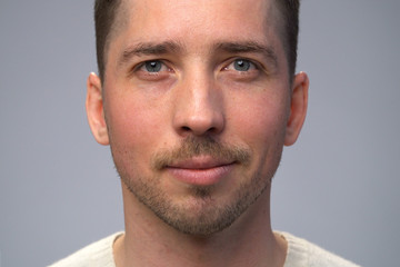 Obraz premium Close up smiling man's face, gray background