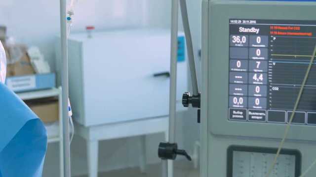 No heartbeat. Hand with a heartbeat monitoring equipment in a surgery. No heartbeat on display. 4K.