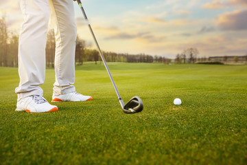 Obraz premium Golf ball on grass in front of golf club