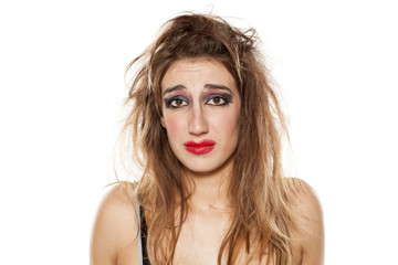 sad beautiful woman with bad makeup and messy hair