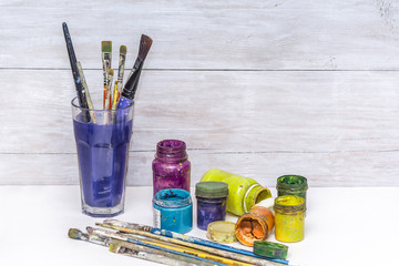 Multicolored plastic cans with paints. Artist workplace background. Old dirty Paints background. Colorful artist palette. Creativity, visual art concept. Art and craft.