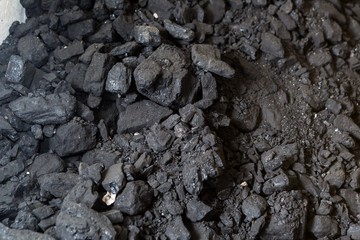 Black coal lying on a pile in house basement