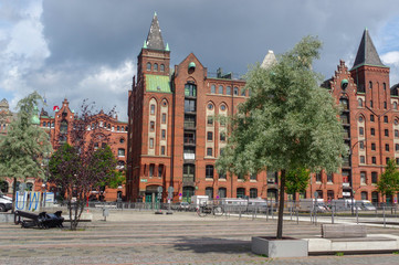 Obraz premium HAMBURG, GERMANY - JULY 18, 2015: the canal of Historic Speicherstadt houses and bridges at evening with amaising skyview over warehouses, famous place Elbe river.