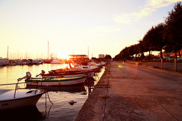 Beautiful quay with yachts and catters near sea on sunset