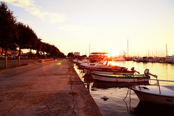 Beautiful quay with yachts and catters near sea on sunset