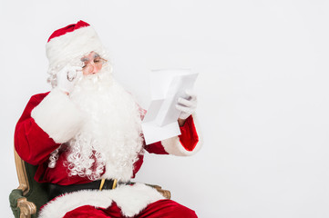 Obraz na płótnie Canvas Santa Claus Reading Letter isolated over white baclground