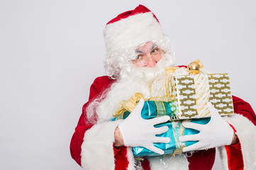 Obraz premium Santa holding many Christmas gifts