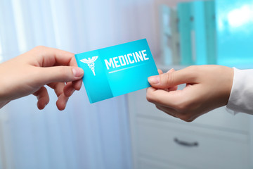 Medical service concept. Female hand giving visiting card