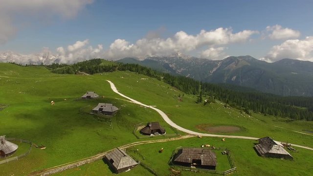 Aerial: Camera Flying Above Mountain Village With Mountain Alps Background At Summer