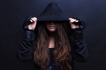 Young female model wearing sports hooded sweatshirt. Black background