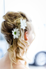 hübsche Frisur mit Blumen einer Braut beim Getting Ready