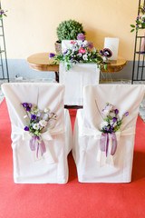 St&uuml;hle vor Pfarrer bei einer Trauung mit Blumen geschm&uuml;ckt