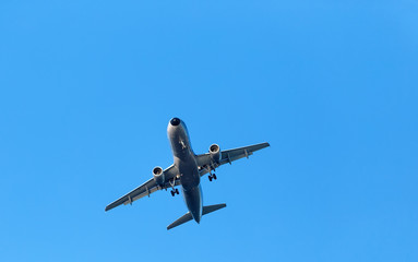 Fototapeta na wymiar dark silhouette of airplane flying over blue skies