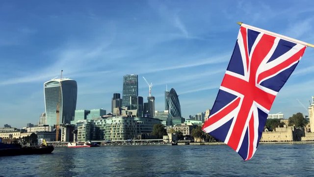 British Union Jack flag flying over the London skyline of the financial City center at the River Thames