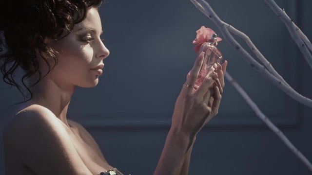 Pretty mother holding a bootle of perfume