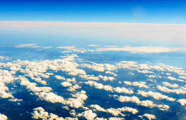 Fototapeta premium Fluffy white clouds and blue sky seen from airplane.